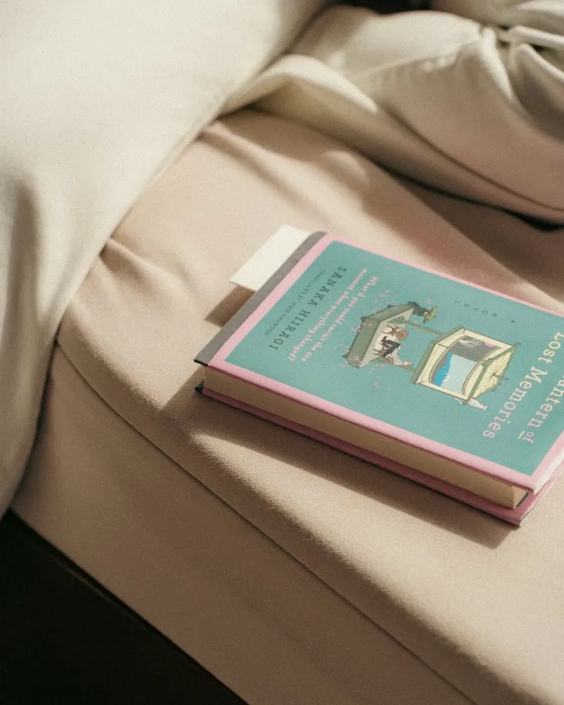 A small book resting on folded cream linen, lit softly from one side.