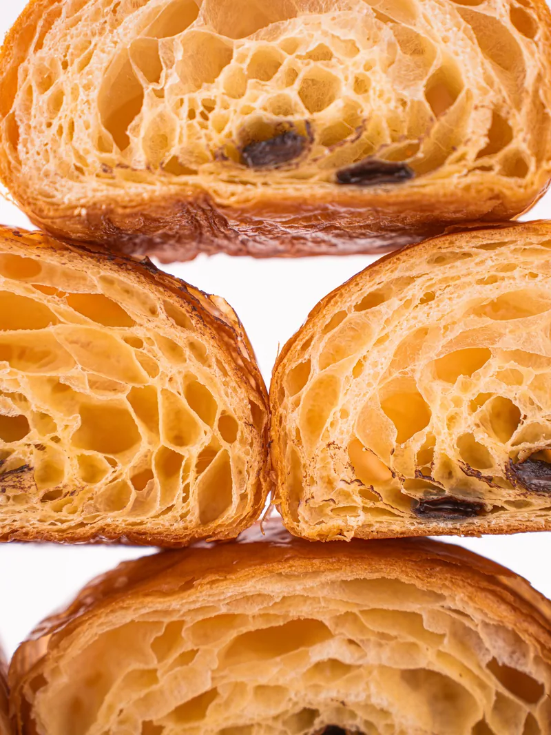 Halved pains au chocolat stacked so the open crumb and the chocolate batons face the camera.