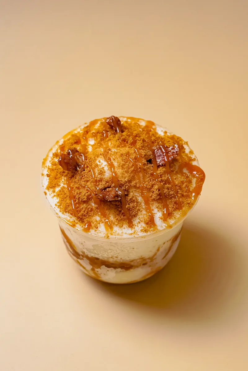 A brulee topped cup dessert on a warm cream ground, shot from above.