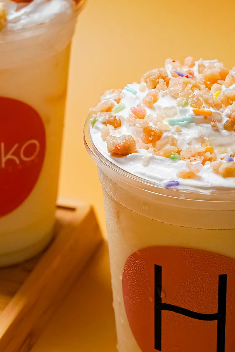 Two branded cups side by side, the round Honiko mark facing out.