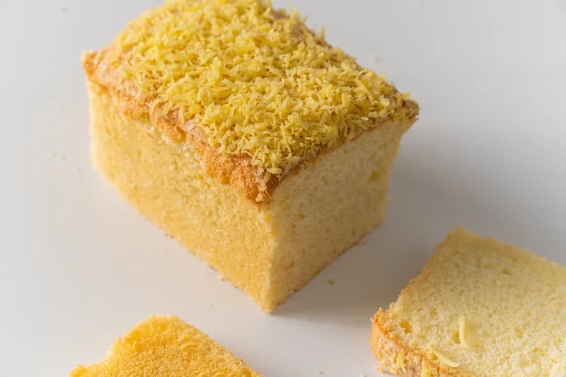 A golden taisan loaf dense with cheese, sliced open.