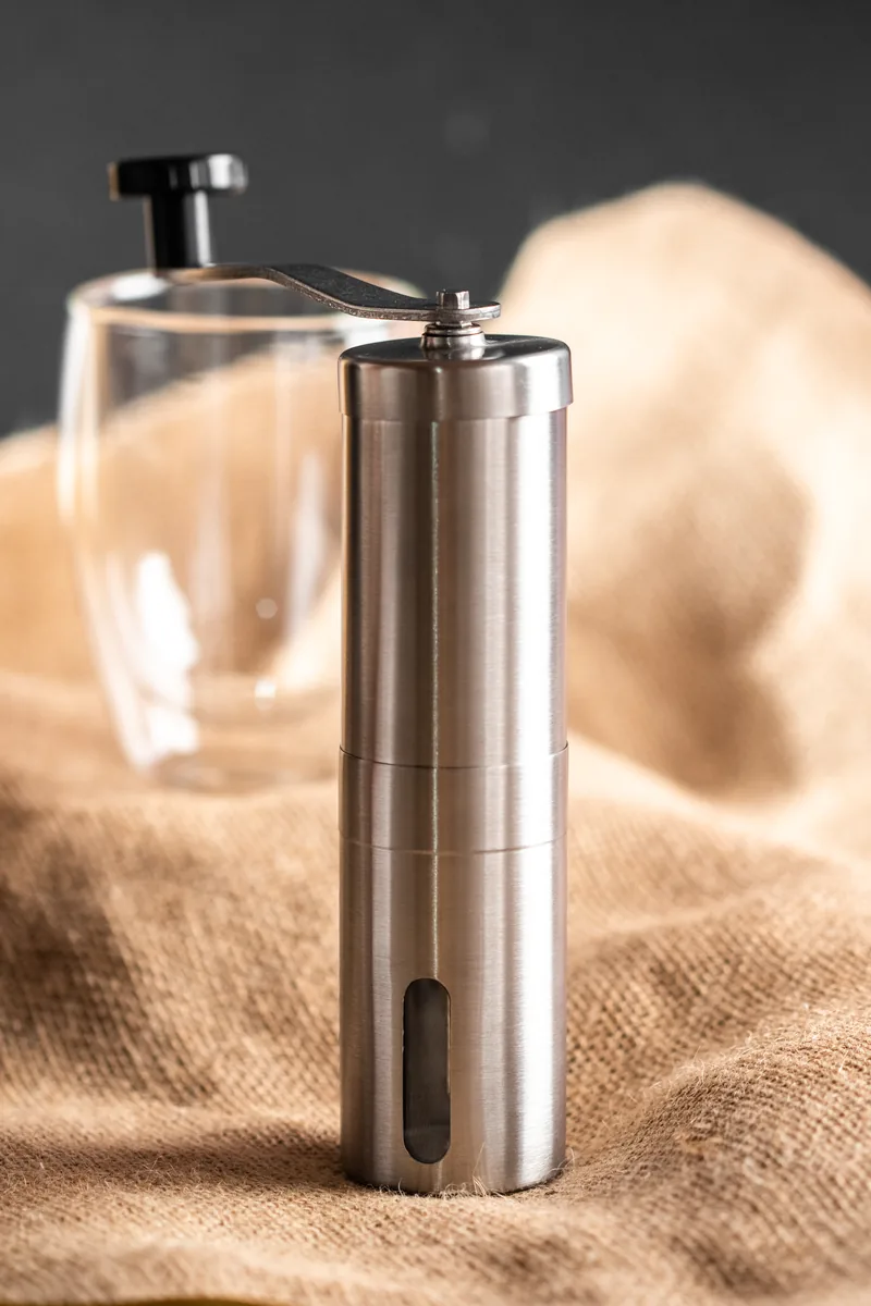 A steel hand grinder standing on rough burlap.