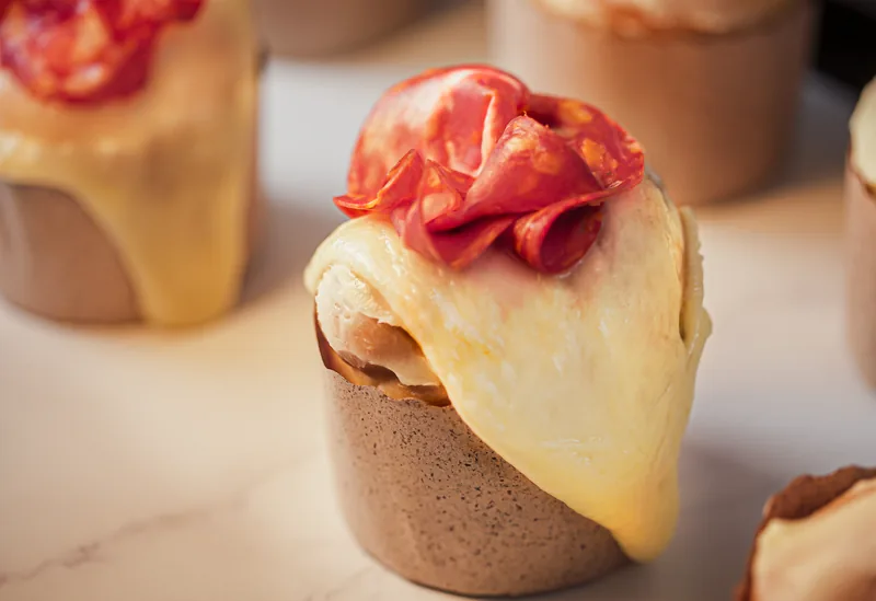 A small pastry crowned with glazed strawberries and dripping cream.